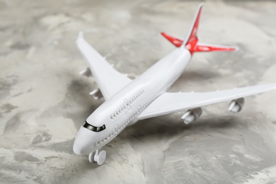 Toy airplane on grey background, closeup. Travel concept