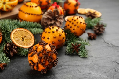 Photo of Pomander balls made of fresh tangerines with cloves  on dark table, space for text. Christmas atmosphere