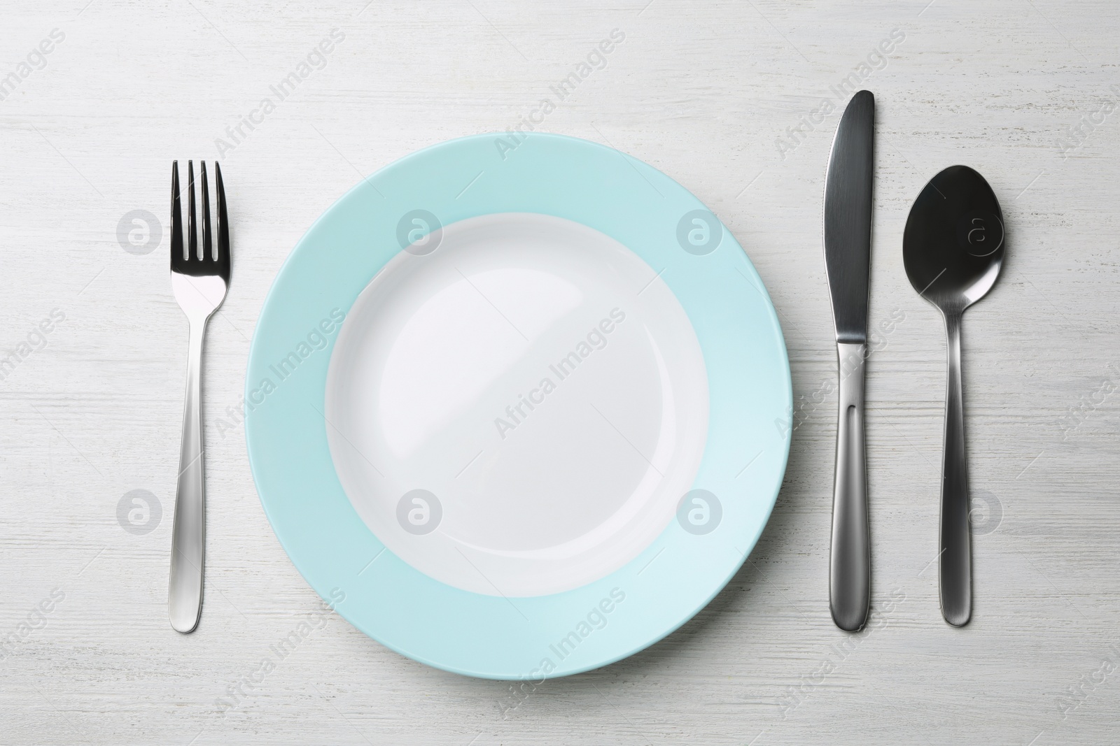 Photo of Stylish ceramic plate and cutlery on white wooden background, flat lay