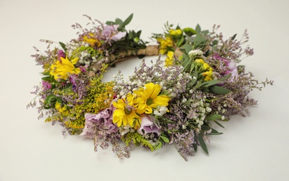 Wreath made of beautiful flowers on white background, closeup