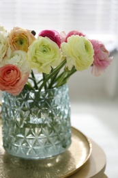 Photo of Beautiful ranunculus flowers in vase on table indoors, closeup