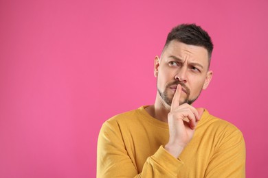 Emotional man on pink background, space for text