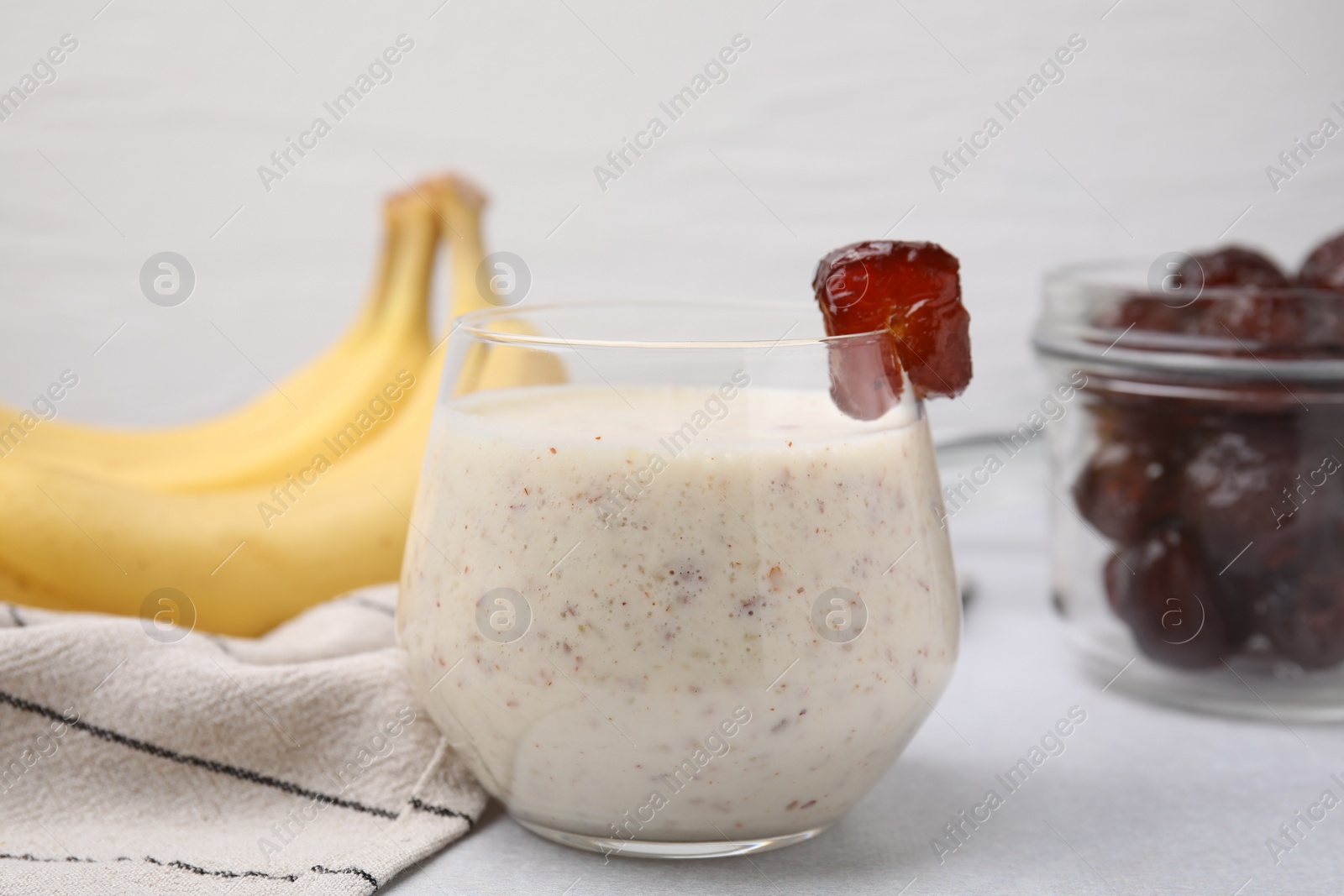 Photo of Glass of delicious date smoothie on white table, closeup