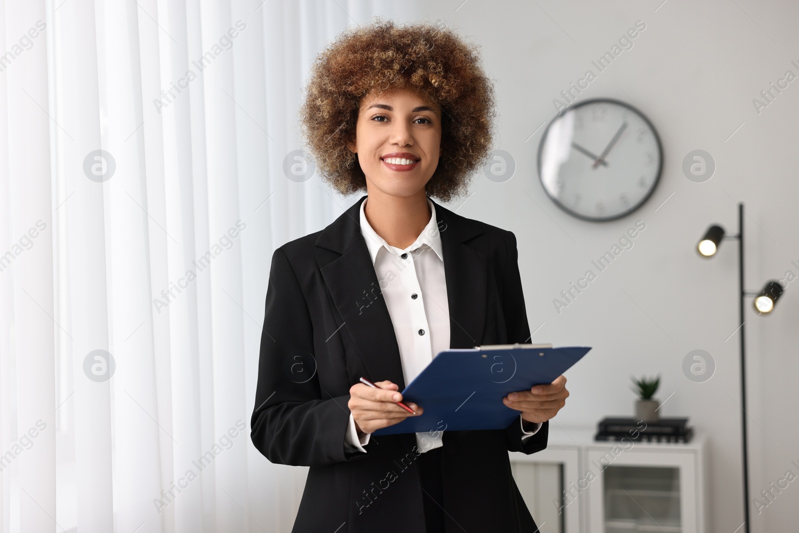 Photo of Happy notary with clipboard and pen in office