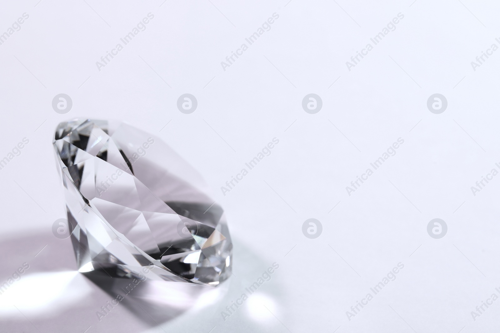 Photo of Beautiful dazzling diamond on pink background, closeup. Space for text