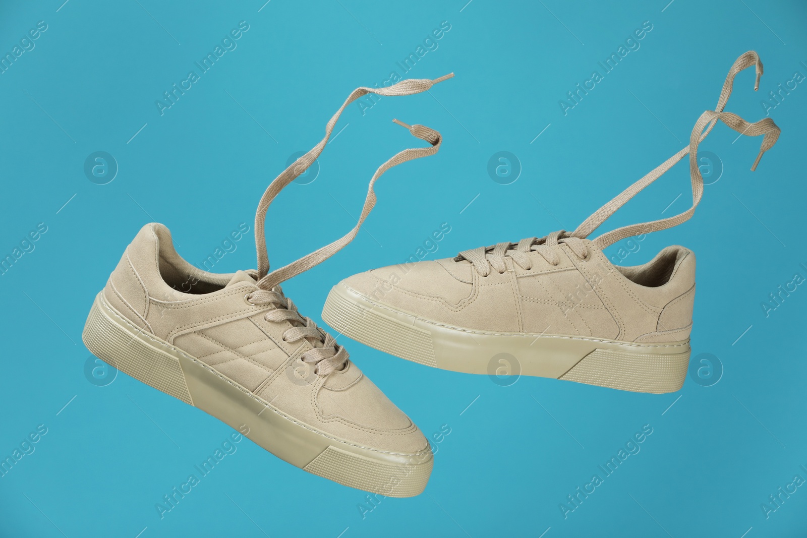 Photo of Pair of stylish white sneakers on blue background