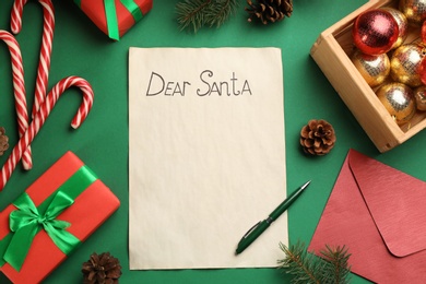 Photo of Flat lay composition with letter saying Dear Santa on green background. Space for text