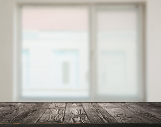 Empty wooden surface and blurred view of modern window 