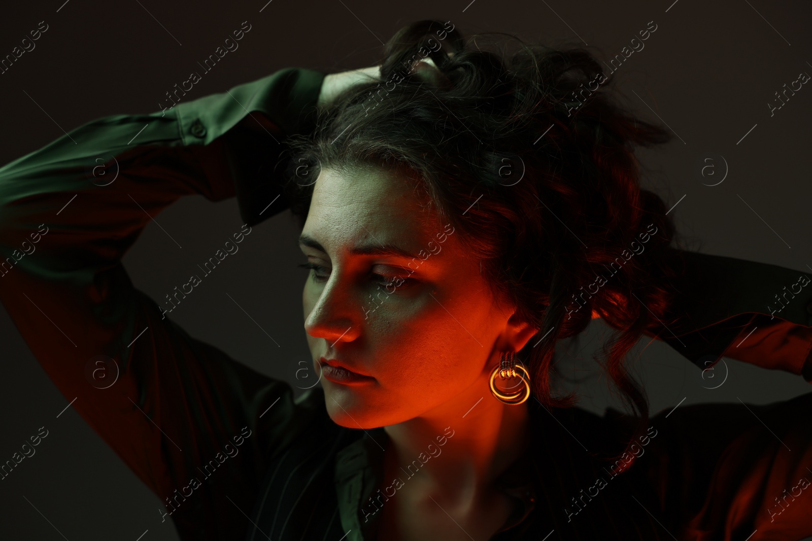 Photo of Portrait of beautiful young woman on dark background with neon lights, closeup