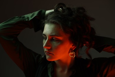 Portrait of beautiful young woman on dark background with neon lights, closeup