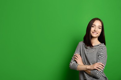Image of Chroma key compositing. Beautiful young woman smiling against green screen