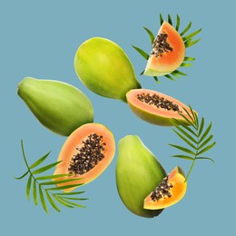 Image of Fresh papaya fruits and green leaves falling on pale light blue background