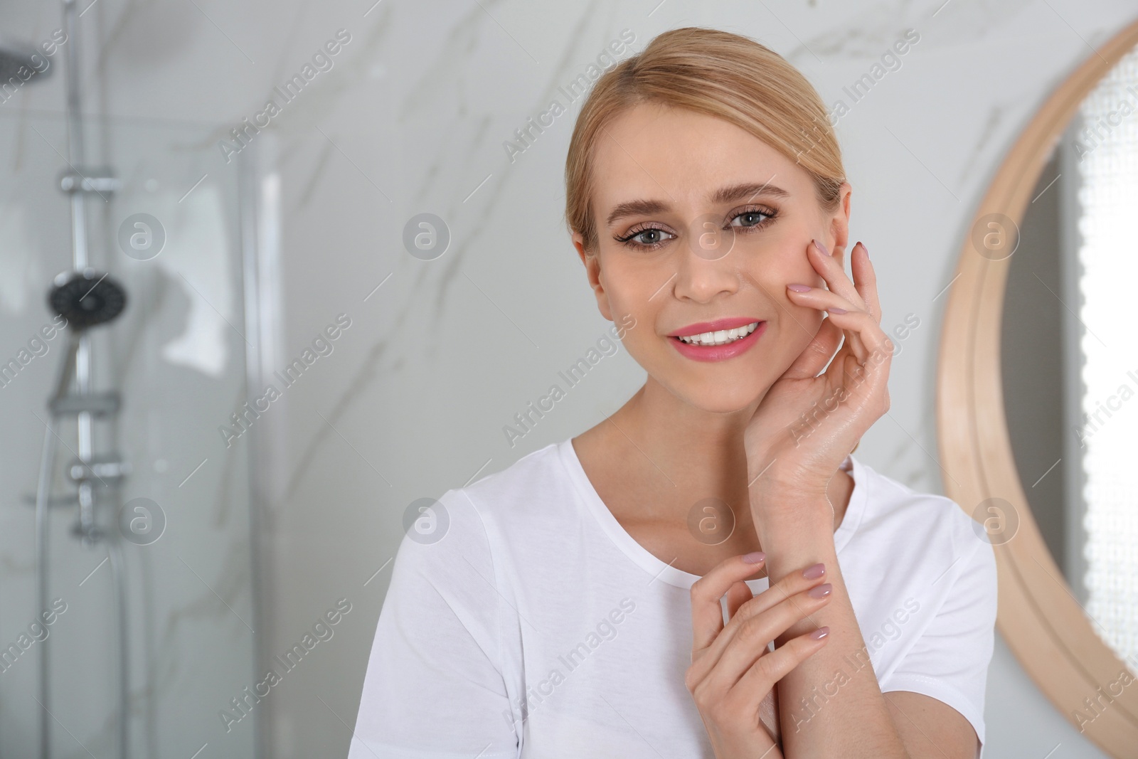 Photo of Happy young woman with clean skin in bathroom