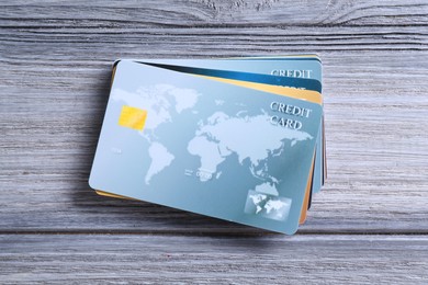 Photo of Credit cards on grey wooden table, top view