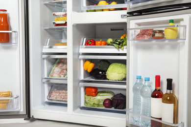 Open refrigerator full of different fresh products