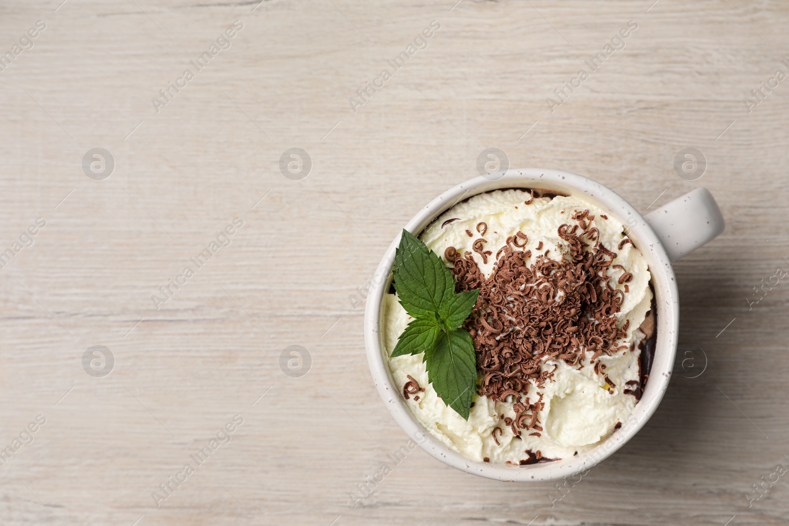 Photo of Cup of delicious hot chocolate with whipped cream and mint on white wooden table, top view. Space for text