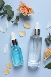 Photo of Flat lay composition with cosmetic serums on light blue background