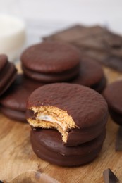 Photo of Tasty choco pies on wooden board, closeup