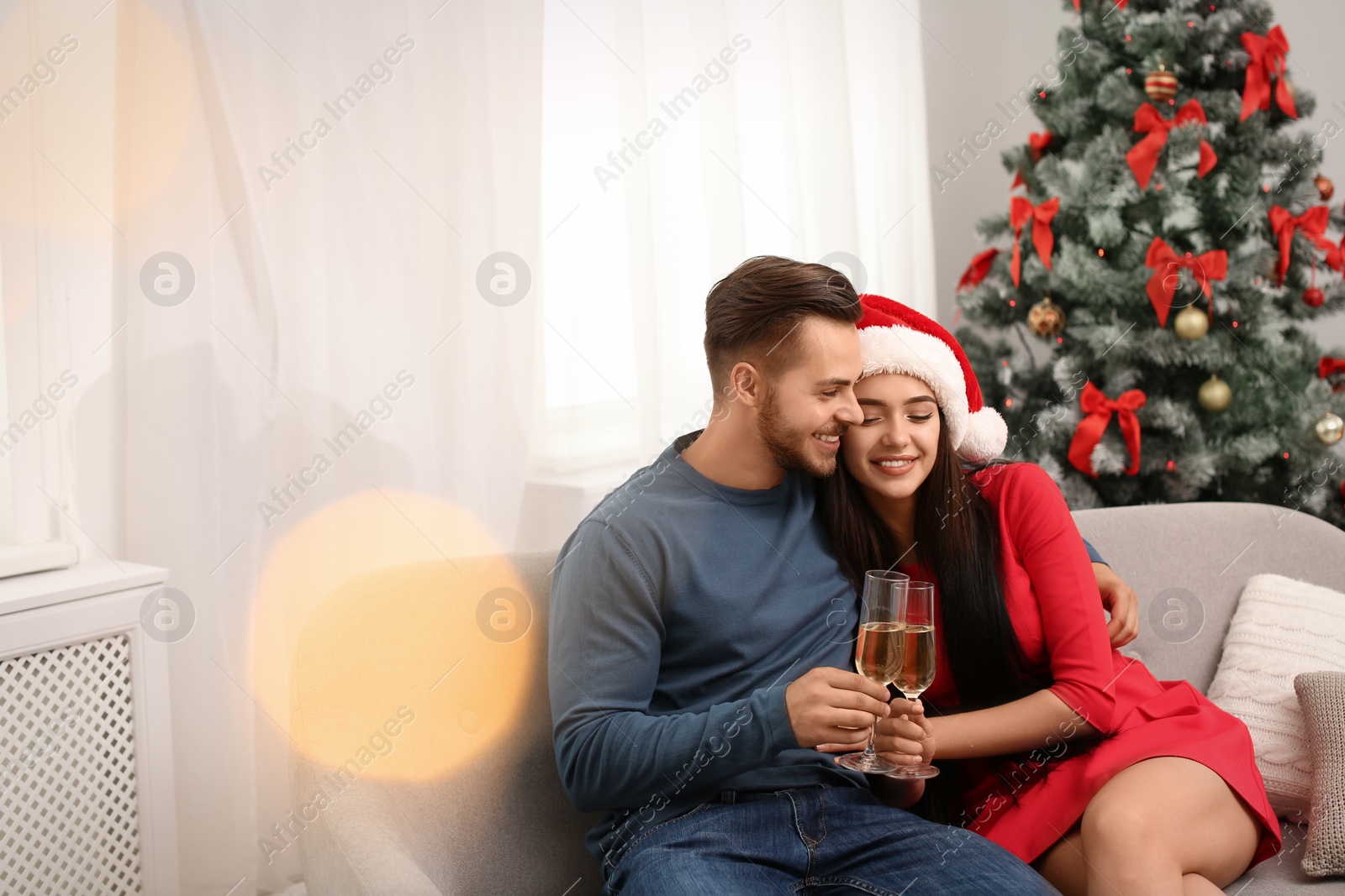 Photo of Young couple with glasses of champagne at home. Christmas celebration