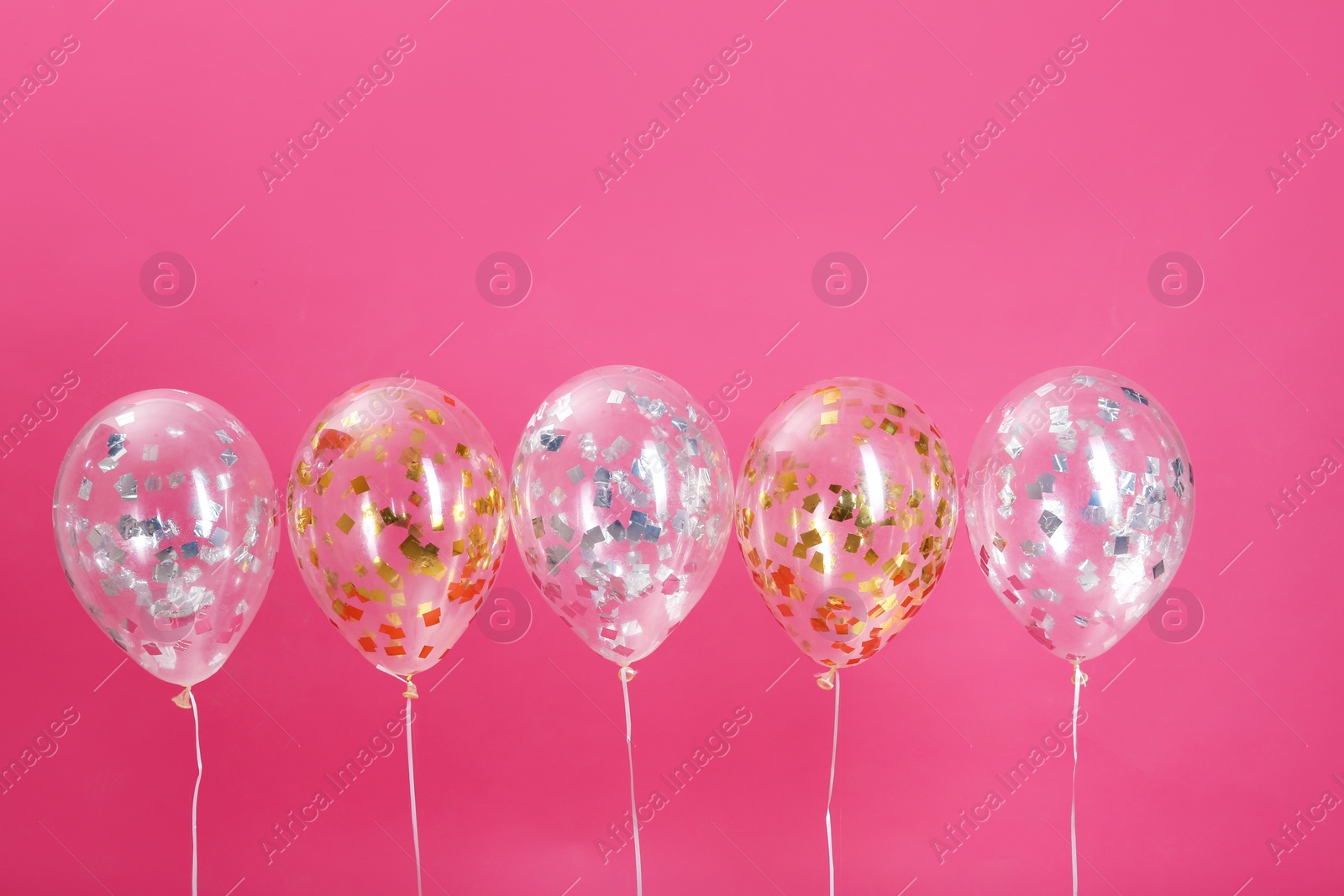 Photo of Bright balloons with sparkles on color background. Space for text