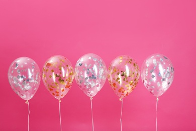 Photo of Bright balloons with sparkles on color background. Space for text