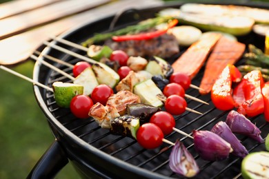 Photo of Delicious grilled vegetables on barbecue grill outdoors, closeup