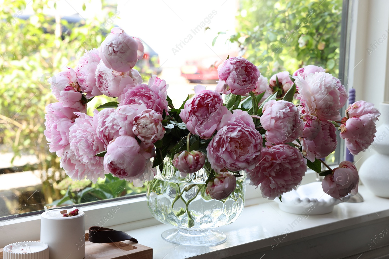 Photo of Beautiful pink peonies in vase on window sill. Interior design