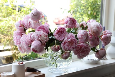 Beautiful pink peonies in vase on window sill. Interior design