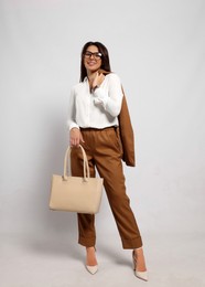 Photo of Young woman with stylish bag on white background