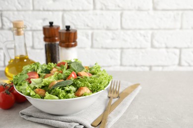 Photo of Delicious salad with chicken, cherry tomato and spinach served on light grey table, space for text