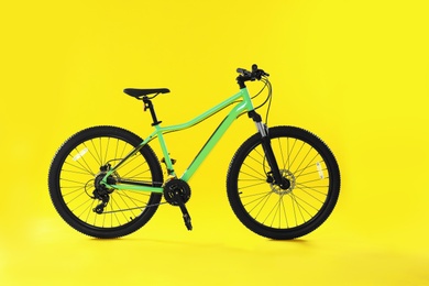 Photo of Modern bicycle on yellow background. Healthy lifestyle