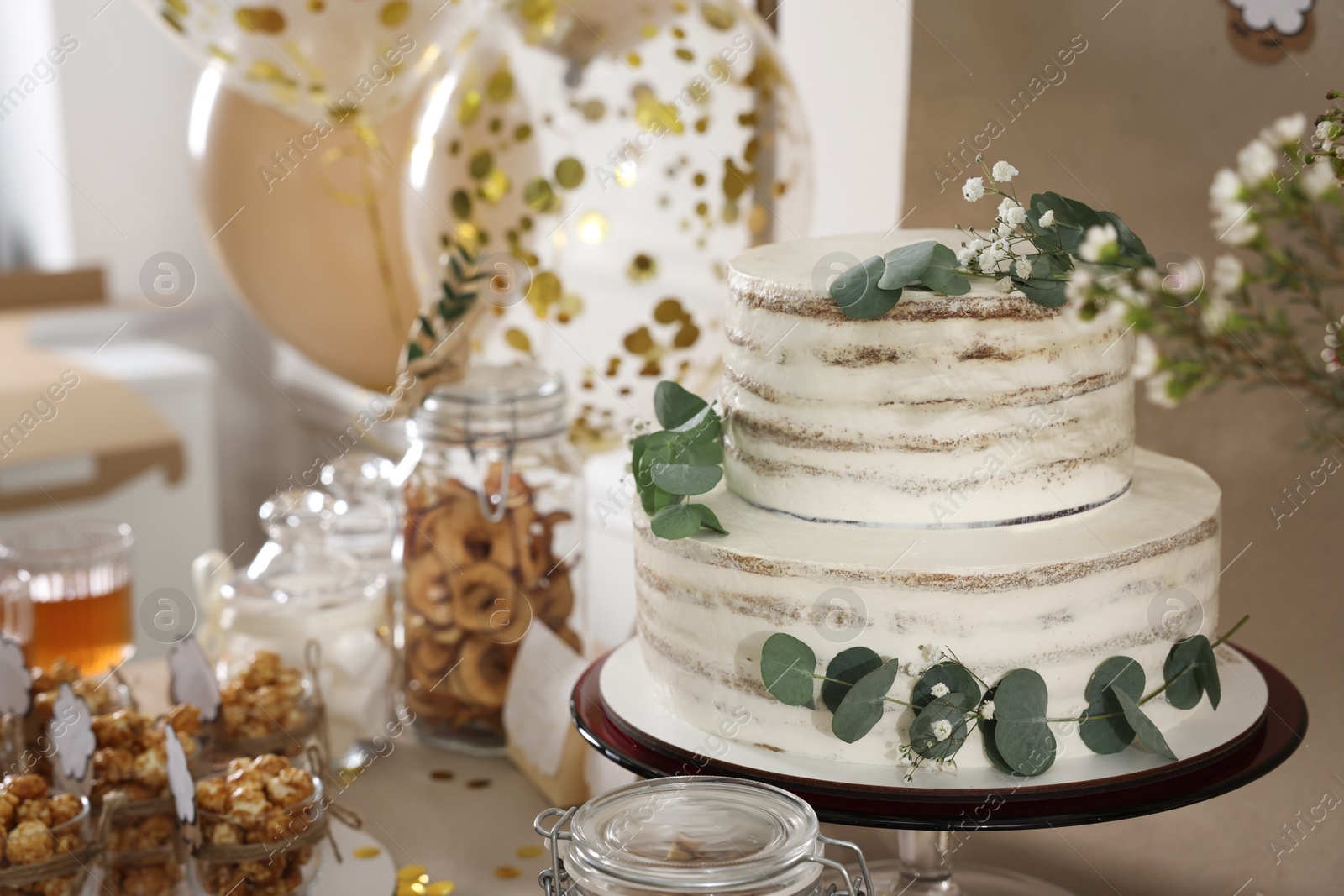 Photo of Beautiful cake and other treats on table in room. Baby shower party