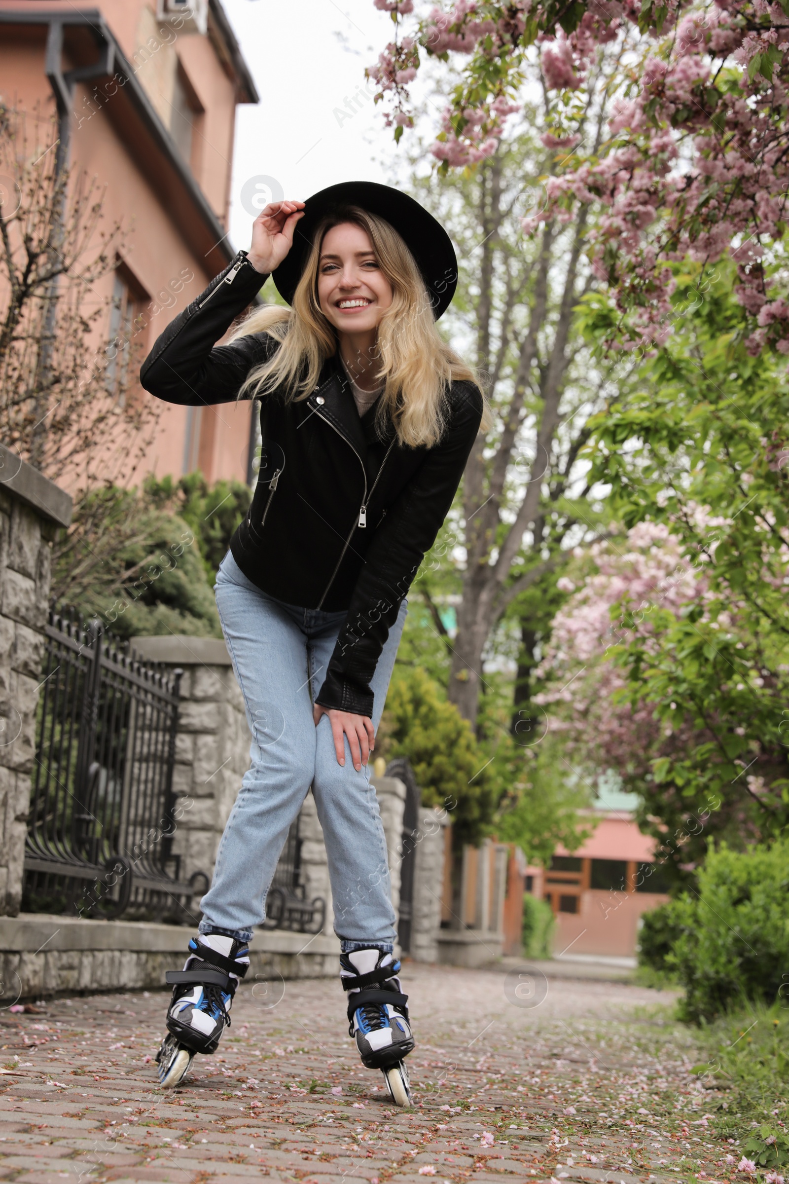 Photo of Young woman roller skating on spring day