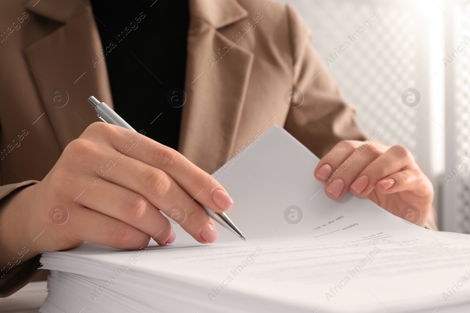 Photo of Woman signing document at table, closeup view