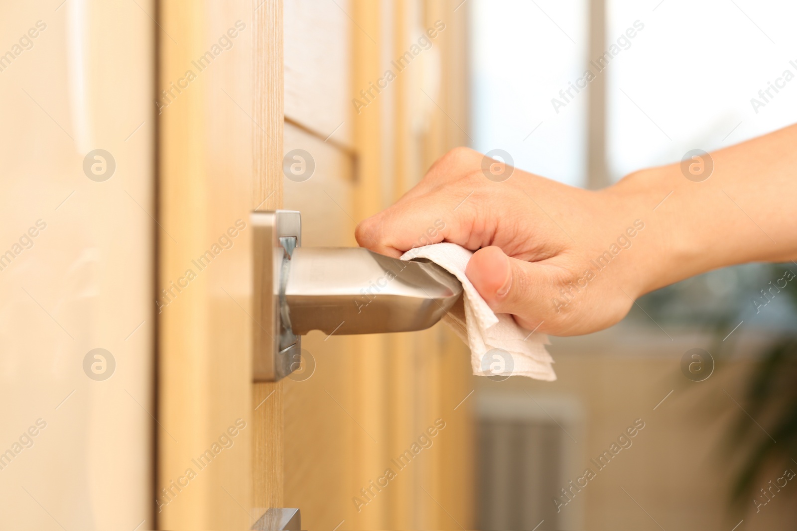 Photo of Woman using tissue paper to open door, closeup