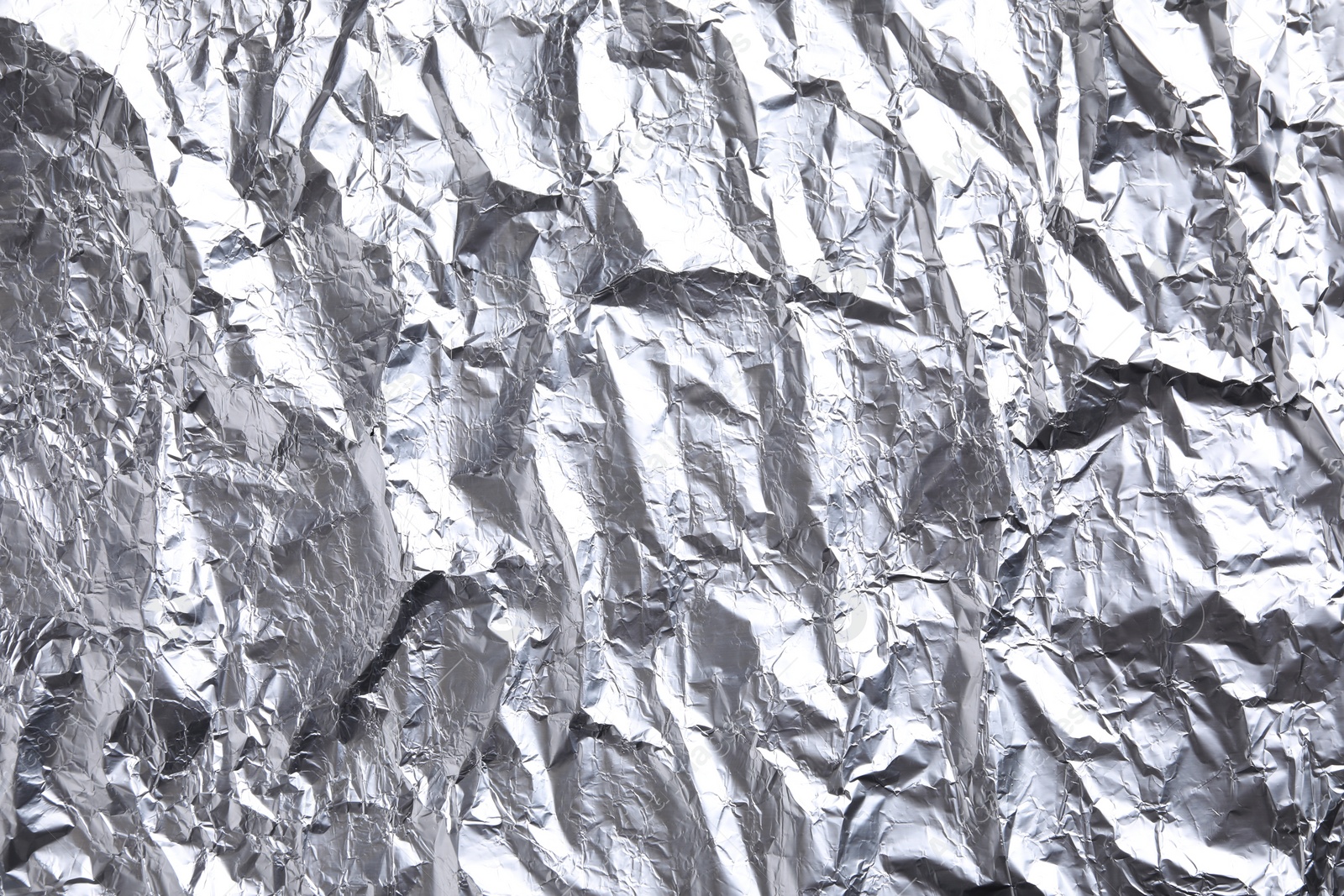 Photo of Crumpled silver foil as background, closeup view