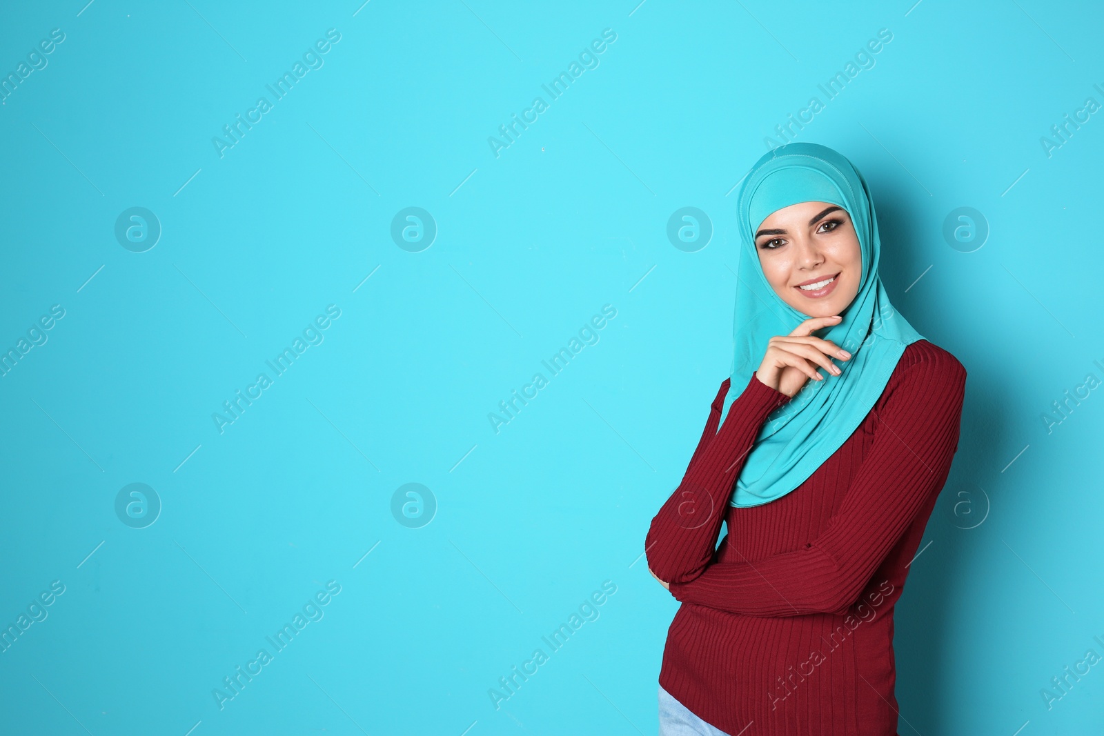 Photo of Portrait of young Muslim woman in hijab against color background. Space for text