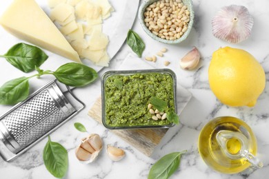 Photo of Flat lay composition with delicious pesto sauce and ingredients on white marble table