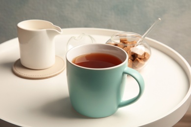 Photo of Cup of black tea on round table