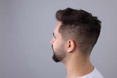 Man with healthy hair on light grey background, space for text