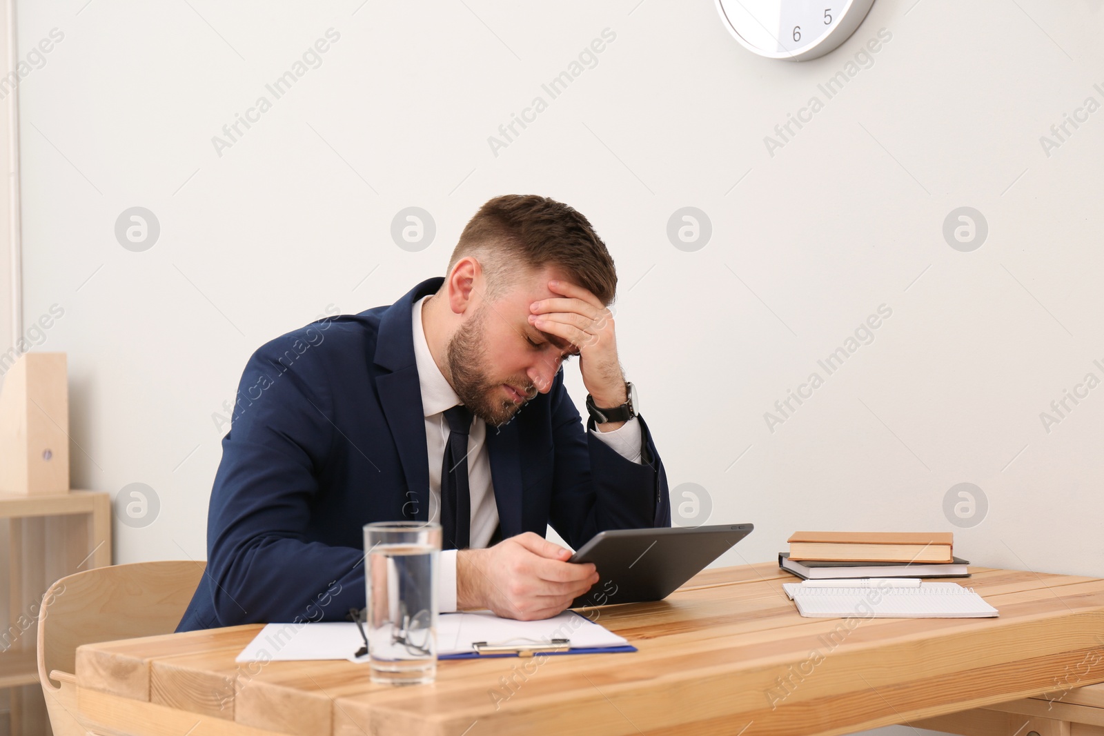 Photo of Man suffering from migraine at workplace in office