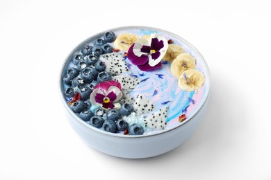 Delicious smoothie bowl with fresh fruits, blueberries and flowers on white background