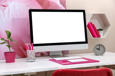Photo of Stylish workplace with modern computer and pink elements indoors. Space for text