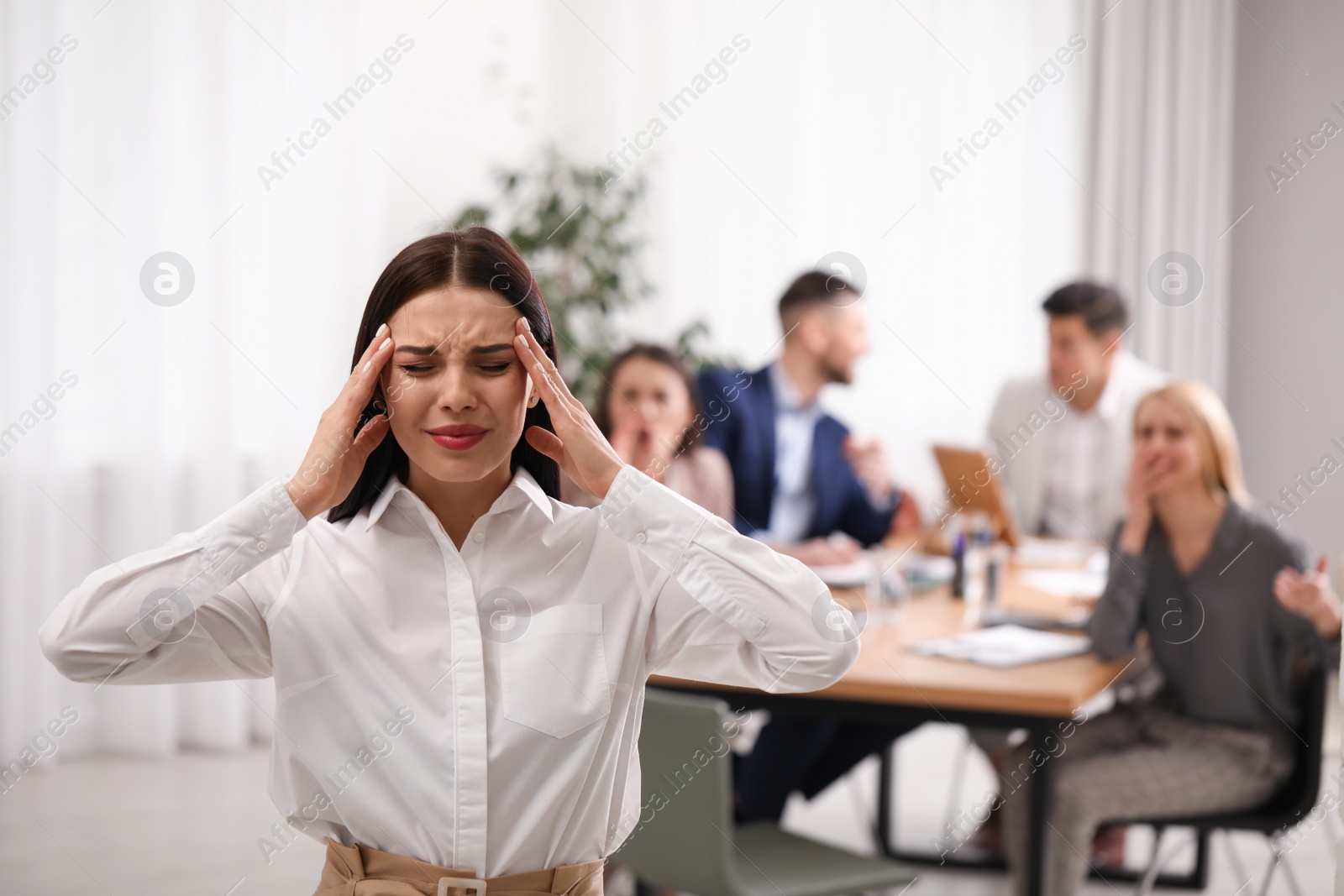 Photo of Coworkers bullying their colleague in office, space for text