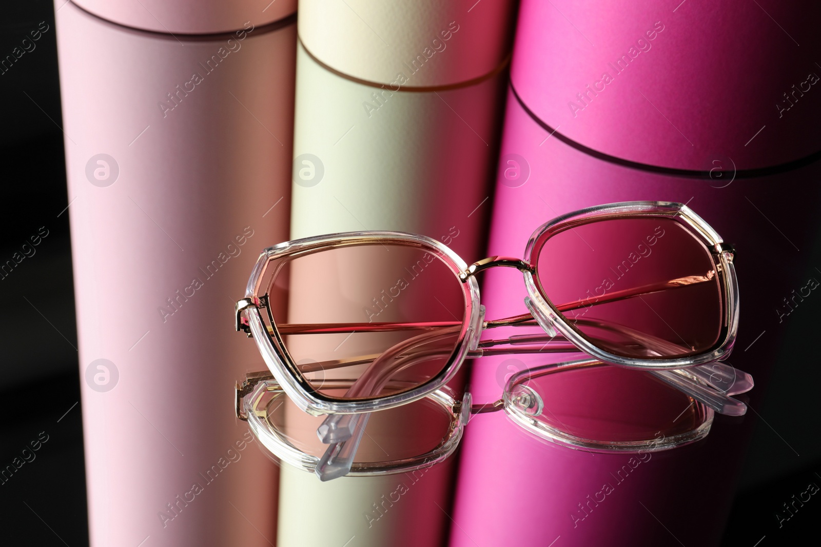 Photo of Stylish sunglasses on glass table. Fashionable accessory