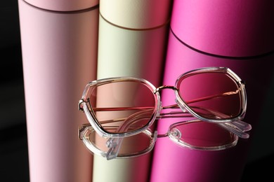 Photo of Stylish sunglasses on glass table. Fashionable accessory