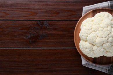 Plate with fresh raw cauliflower on wooden table, top view. Space for text