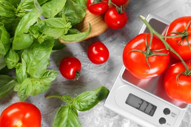 Kitchen scale with tomatoes and basil on grey textured table, flat lay