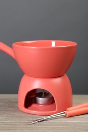 Photo of Fondue set on wooden table, closeup. Kitchen equipment