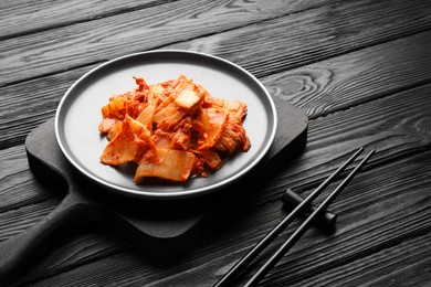 Delicious kimchi with Chinese cabbage served on black wooden table